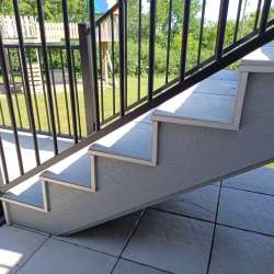Locking in DekTek's concrete deck tiles installed on stairs with aluminum edge trim in Burnsville, MN